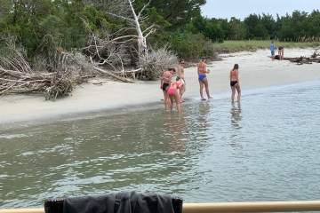 a group of people on a beach near a body of water